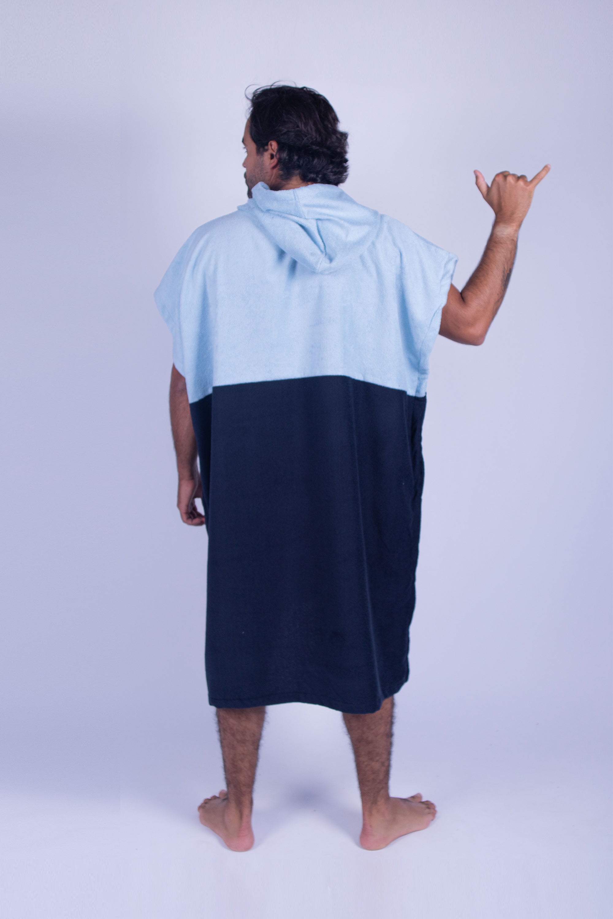 Poncho toalla cambiador de dos colores (Baby azul y azul marino), con bolso en frente y gorro. Ideal para cambiarte en cualquier lugar cómodamente y estar en el después del agua.
