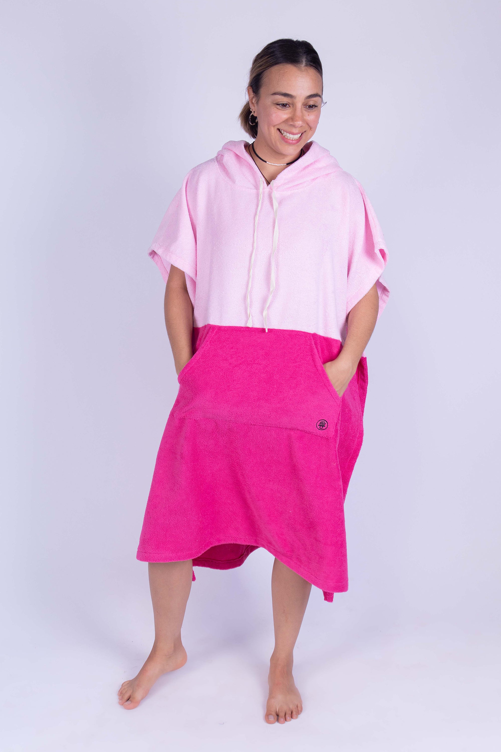 Poncho toalla cambiador de dos colores (Baby pink y rosa mexicano), con bolso en frente y gorro. Ideal para cambiarte en cualquier lugar cómodamente y estar en el después del agua.
